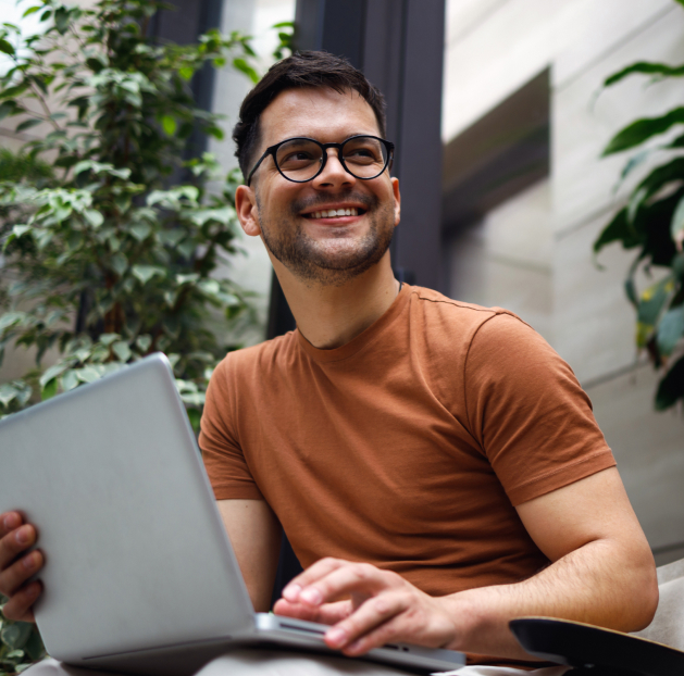 Male leaning on desk with laptop