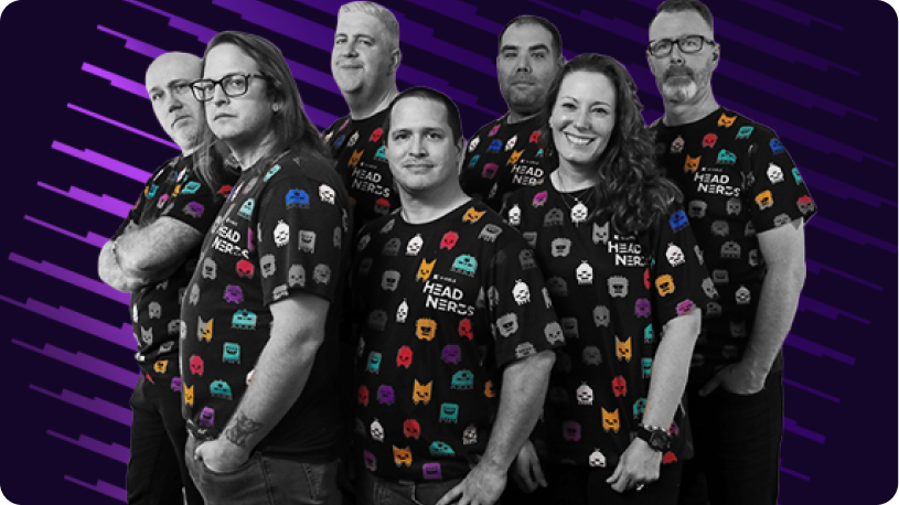 Group photo of team members wearing matching shirts with colorful icons labeled 'HEAD NERDS', representing a collaborative tech team